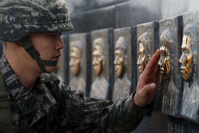 천안함 피격사건 5주기를 나흘 앞둔 22일 해병대 장병이 백령도에 자리한 천안함 46용사 위령탑을 찾아 전몰 장병의 동판 얼굴을 매만지고 있다. 인천=연합뉴스