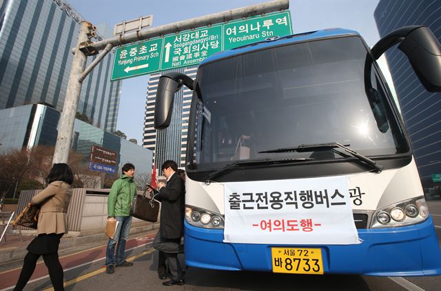 지하철 9호선 2단계 연장구간이 개통한 후 첫 출근이 이뤄진 30일 오전 서울 영등포구 여의도역에서 출근전용 직행버스를 이용한 승객들이 차에서 내리고 있다. 연합뉴스