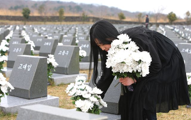 제67주년 4·3희생자 추념식을 일주일 앞둔 27일 오후 제주대 학생들이 제주4·3평화공원 행방불명희생자 위령비를 찾아 비석에 조화 꽂기 봉사활동을 펼치고 있다. 제주=연합뉴스