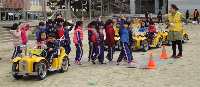 대구 달서구 월촌초등학교 어린이들이 지난 7일 교내 운동장에서 모형 차량이 달리는 가운데 안전하게 횡단보도 건너기를 체험하고 있다. 달서구는 6월26일까지 관내 11개 초등학교 2학년생을 대상으로 ‘체험으로 즐거운 어린이 교통안전교육’을 실시한다. 대구 달서구 제공/2015-04-08(한국일보)