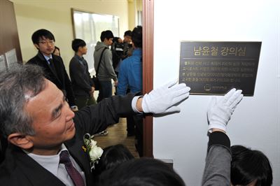 세월호 참사 당시 학생들을 구하고 희생된 단원고 교사 남윤철씨를 기리기 위해 8일 국민대에서 열린 '남윤철 강의실' 명명식에서 남씨의 아버지 남수현 충청대 교수가 현판을 쓰다듬고 있다. 국민대 제공