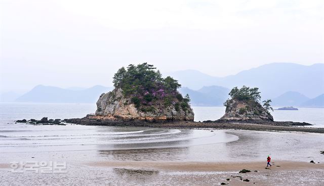 여행객들이 일몰이 아름다운 내나로도의 형제섬 해변을 산책하고 있다.