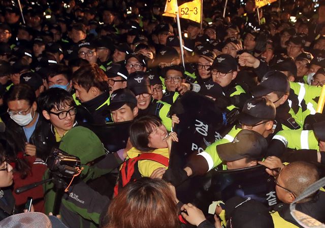 11일 저녁 서울 광화문광장에서 세월호 선체 인양과 세월호 특별법 시행령 폐지를 촉구하는 문화제에 참석한 세월호 유가족이 청와대를 향해 행진하려다 차단벽 앞에서 경찰에 막히고 있다. 연합뉴스