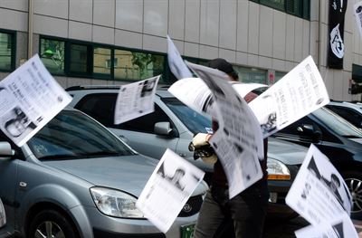 13일 오후 서울 동대문구 답십리동 경남기업 본사 사옥 앞에서 '민주주의를 염원하는 시민들'이라는 단체의 회원이 '성완종 리스트'와 관련해 박근혜 대통령을 규탄하는 전단지를 뿌리고 있다. 뉴시스