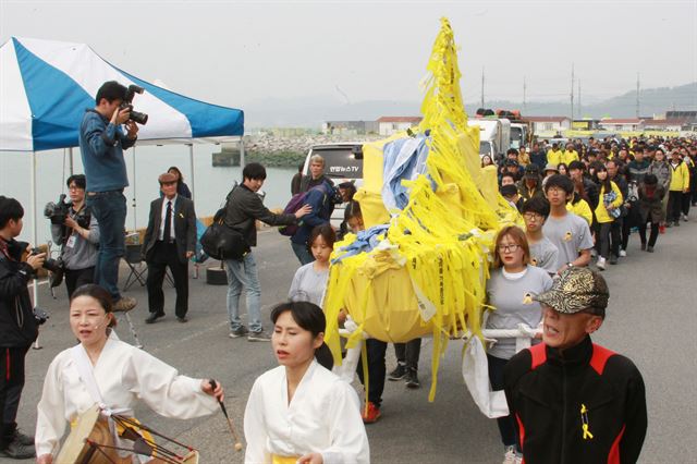 세월호 참사 1주기를 하루 앞둔 15일 전남 진도 팽목항에서 위령제를 마친 세월호 희생자 유가족들이 노란 리본으로 세월호를 형상화한 상여를 앞세우고 사고 해역으로 이동하기 위해 부두를 향해 걷고 있다. 진도=연합뉴스