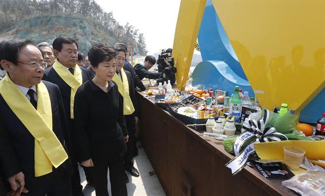 박근혜 대통령이 세월호 1주년을 맞은 16일 오전 전남 진도군 팽목항을 방문, 희생자와 실종자를 위해 마련된 추모 메시지와 음식들이 놓인 단 앞을 지나가고 있다. 연합뉴스