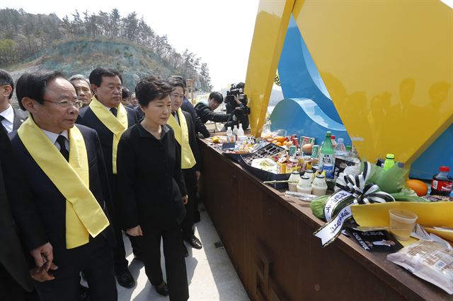 박근혜 대통령이 세월호 1주년을 맞은 16일 전남 진도군 팽목항을 방문, 희생자와 실종자를 위해 마련된 추모 메시지와 음식들이 놓인 단 앞을 지나가고 있다. 진도=홍인기기자 hongik@hk.co.kr