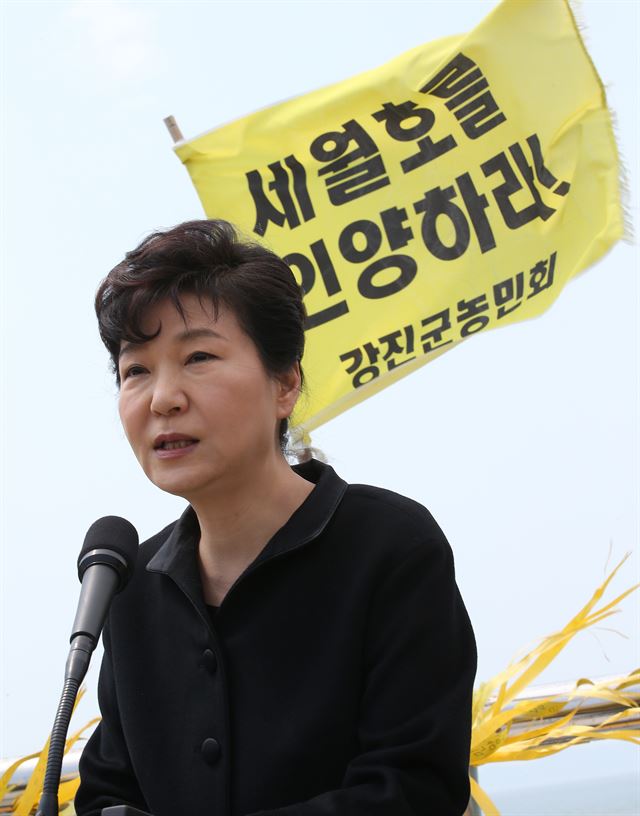 박근혜 대통령이 세월호 참사 1주기인 16일 전남 진도항 방파제에서 세월호 인양을 촉구하는 농민단체 깃발이 펄럭이는 가운데 대국민 담화를 발표하고 있다. 진도=청와대사진기자단