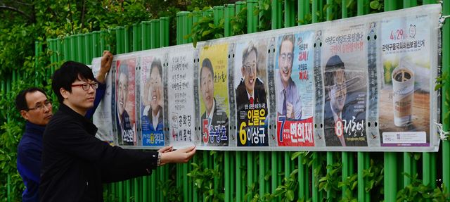 4ㆍ29 재보선의 공식 선거운동이 시작된 16일 서울 관악구 신성초등학교 주변에서 선관위 직원들이 선거 벽보를 부착하고 있다. 뉴시스