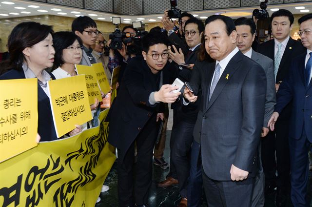 이완구 국무총리가 15일 국회 본회의장으로 이동하던 중 로텐더 홀에서 사퇴를 촉구하는 정의당 의원들을 바라보고 있다. 오대근기자 inliner@hk.co.kr