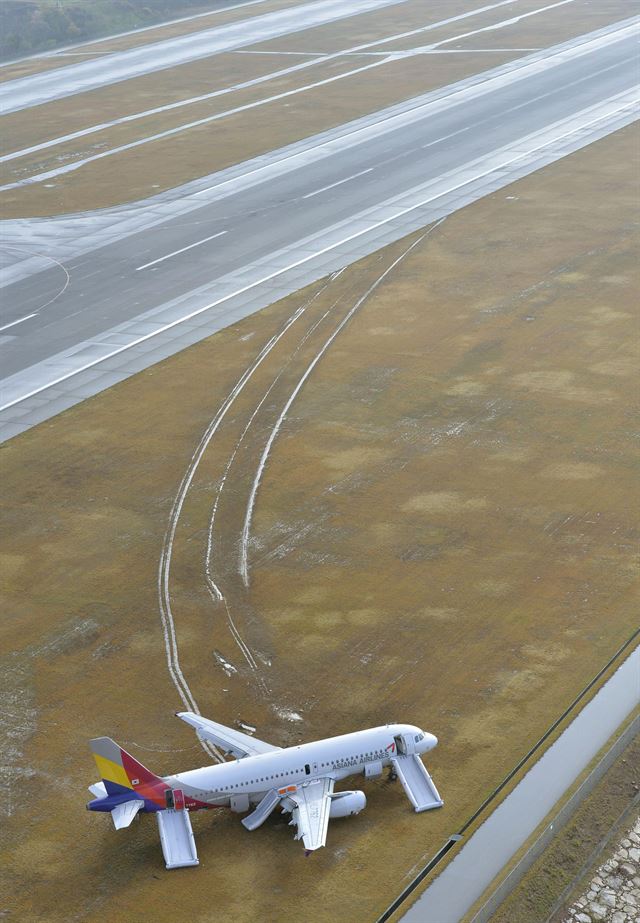 전날 밤 일본 서부 히로시마 공항 착륙 중 활주로를 벗어난 아시아나항공 162편(에어버스 A320기, 앞쪽)이 15일 사고 지점에 멈춰 서 있는 모습. 이번 사고로 기체에서 불길이 일었다는 증언이 곳곳에서 나오고 있으며, 소방대가 출동해 진화했다고 관계자들은 전했다. 사고로 승객 73명 중 18명이 경상을 입었다. 미하라=AP 연합뉴스