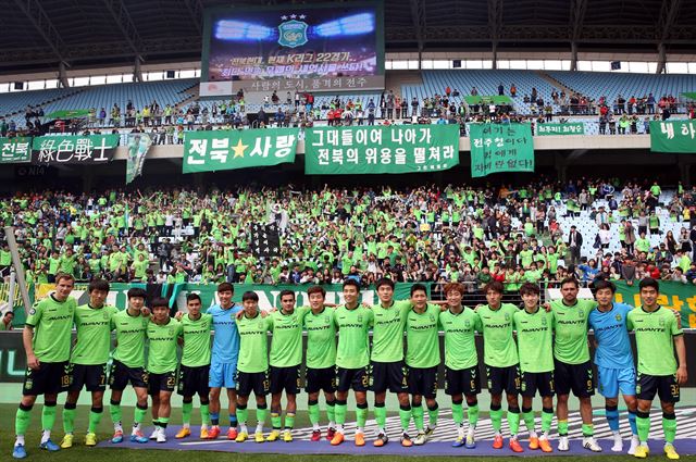 최강희 감독이 이끄는 프로축구 전북 현대 선수들이 18일 전주월드컵경기장에서 열린 K리그 클래식 제주 유나이티드와 경기에서 1-0으로 승리, 22경기 연속 무패 신기록을 작성한 뒤 어깨동무를 하고 팬들에게 인사하고 있다. 뉴시스