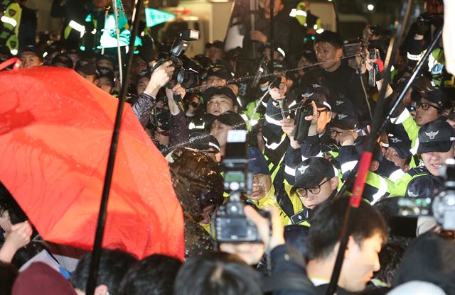 11일 저녁 서울 광화문광장에서 세월호 선체 인양과 세월호 특별법 시행령 폐지를 촉구하는 문화제 뒤 참가자들이 청와대를 향해 행진하려다 차단벽 에 막힌 뒤 경찰이 집회 참가자들을 향해 최루액을 발사하고 있다. 연합뉴스