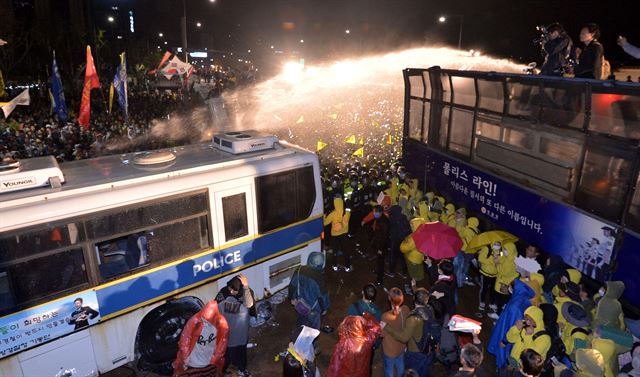 18일 오후 경찰이 서울광장을 출발해 광화문으로 행진을 시도하는 세월호 1주기 범국민대회 참가자들에게 물대포를 살포하고 있다. 뉴시스