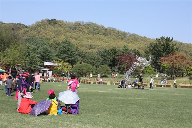 25일 충북 청주 청남대를 찾은 관광객들이 헬기장에서 봄 햇살을 만끽하고 있다. 잔디가 잘 보존된 이곳에서 2003년 4월 노무현 대통령이 지역 주민과 함께 청남대 개방 행사를 가졌다.