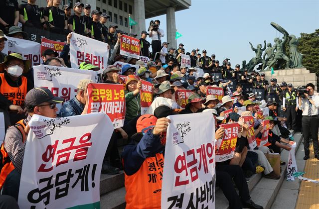 전국공무원노동조합원들이 1일 서울 여의도 국회 앞에서 기습 시위를 열고 공무원연금 개악 중단 등을 주장하는 플래카드를 펼쳐 들고 있다. 연합뉴스