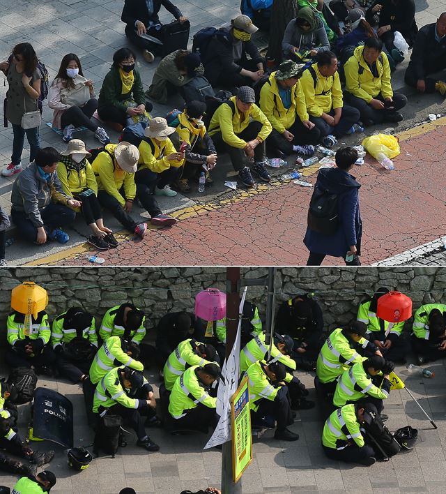 2일 오전 서울 종로구 안국동사거리에서 행진 진로를 두고 대치를 벌이던 세월호 집회 참가자들과 경찰들이 각각 거리에 앉아 휴식을 취하고 있다. 연합뉴스