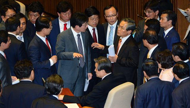 공무원연금 개혁안 처리를 놓고 종일 진통을 겪은 6일 국회 본회의장에서 여야 의원들이 지켜보는 가운데 유승민(두 번째 줄 왼쪽 세 번째) 새누리당, 우윤근(네 번째) 새정치민주연합 원내대표가 이야기를 나누고 있다. 오대근기자 inliner@hk.co.kr