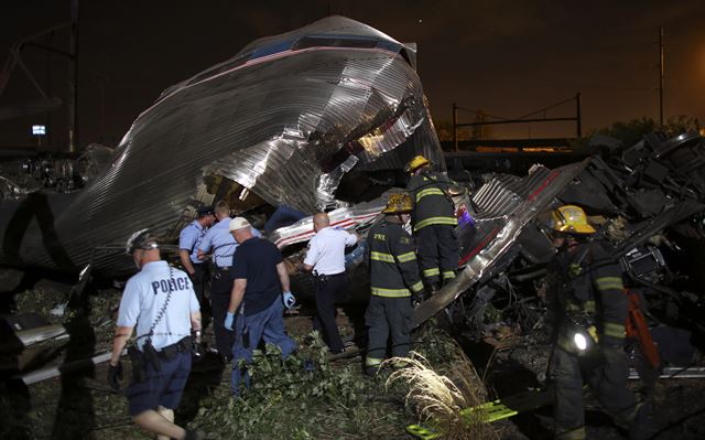 미국 워싱턴DC를 떠나 뉴욕으로 가던 암트랙(AMTRAK) 여객열차가 12일(현지시간) 밤 필라델피아에서 탈선사고로 최소 5명이 숨지고 50여 명이 부상을 당한 가운데 기차가 처참하게 부서진 사고 현장에서 긴급구조대원이 작업을 하고 있다. AP 연합뉴스