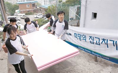 김한기(오른쪽) 대림산업 건축사업본부장이 희망의 집 고치기 활동을 위해 자재를 나르고 있다. 대림산업 제공