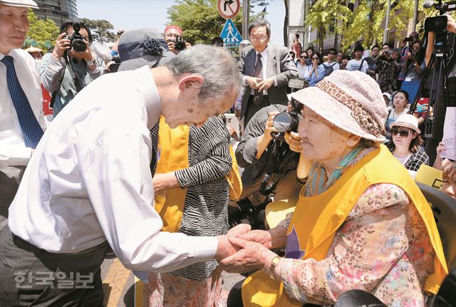 일본 교회 관계자들로 구성된 '사죄와 화해 방문단'의 단장 무라오카 타카미츠 네덜란드 레이던대 명예교수가 27일 서울 종로구 일본대사관 앞에서 열린 수요집회에 참석해 길원옥 할머니에게 허리 숙여 일본군 위안부 문제와 일본 정부의 태도에 대해 사과하고 있다. 배우한기자 bwh3140@hk.co.kr