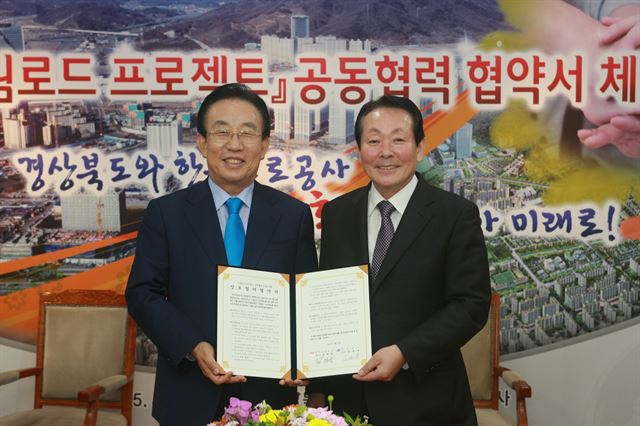 김학송(오른쪽) 한국도로공사 사장과 김관용 경북도지사가 지난달 15일 경북도청에서 상호협력 협약을 체결한 뒤 취재진 앞에서 포즈를 취하고 있다. 한국도로공사 제공