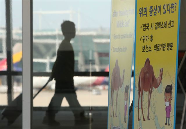 메르스(중동호흡기증후군) 감염자가 18명으로 늘어난 1일 오후 인천공항 검역대 앞에 메르스 감염 증상과 대처 요령을 담은 안내문이 세워져 있다. 연합뉴스