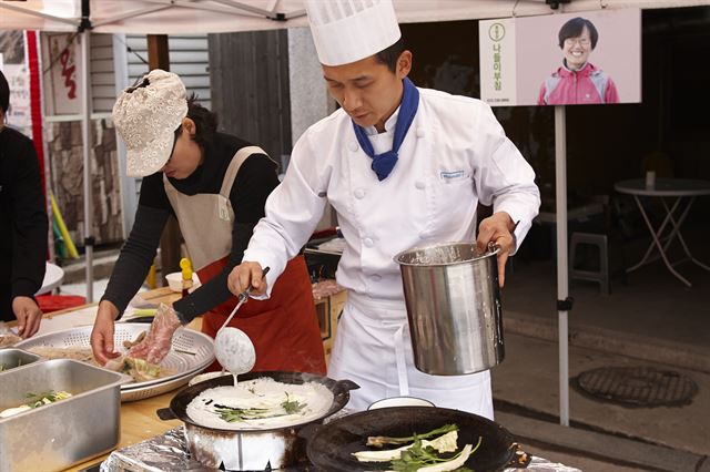 '현대카드 봉평장 프로젝트'에 참여한 현대카드 구내식당 요리사(오른쪽)가 봉평의 특산물인 메밀을 이용해 직접 개발한 메밀전을 부치고 있다. 현대카드 제공