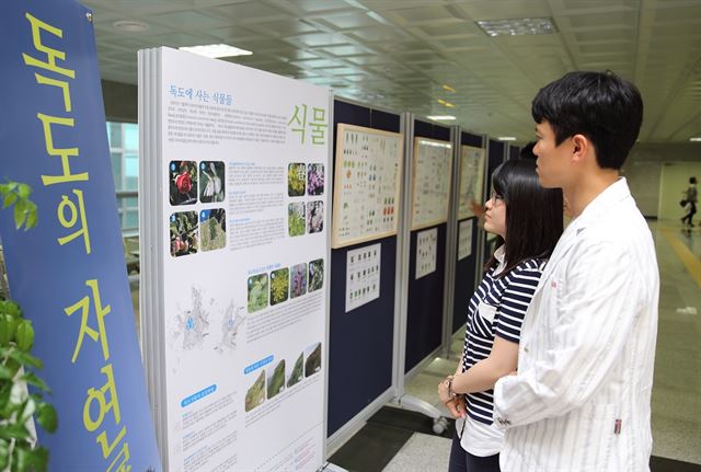 시민들이 동대구역에서 열리는 '독도의 자연전'에 전시 중인 자료를 살펴보고 있다. 경북대 제공/2015-06-04(한국일보)