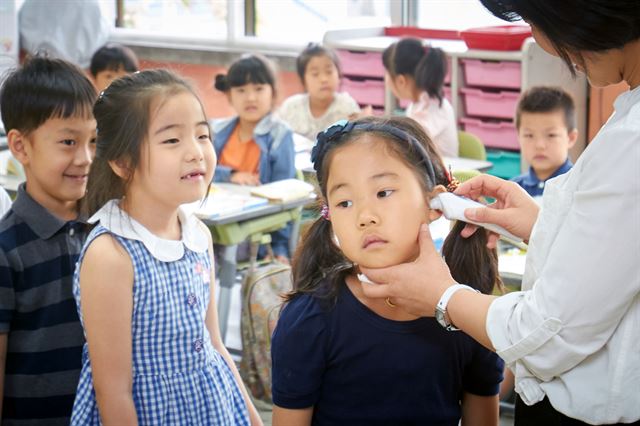 8일 오전 종로구 혜화초등학교 1학년 교실에서 담임 선생님이 어린이들의 체온을 재고 있다. 중동호흡기증후군(메르스) 확산이 계속되고 있는 가운데 서울시교육청은 강남구와 서초구의 유치원 69개, 초등학교 57개 등 126곳이 이날부터 10일까지 일괄휴업한다고 밝히면서 이외 정상적으로 운영되는 학교에게 등교한 학생 전체에 대해 매일같이 발열체크를 할 것을 당부했다.황재성 기자 goodluck@snhk.co.kr