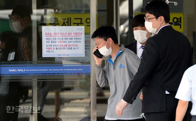 10일 오후 ‘메르스 전담’추가 병원으로 지정된 동작구 서울시보라매병원 응급의료센터에서 메르스 의심환자가 누군가와 통화를 하며 보안요원들의 안내를 받고 있다. 서재훈기자 spring@hankookilbo.com