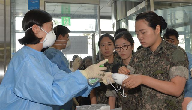 12일 대전 서구 대청병원 입구에서 군 의료진이 손 소독과 마스크를 착용하고 있다. 국방부는 대전시의 요청으로 중동호흡기증후군(메르스) 환자가 발생한 대청병원에서 진료 활동을 펼칠 의료 인력을 파견했다. 사진공동취재단