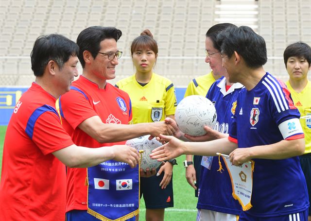 새누리당 정병국(왼쪽서 두 번째) 의원이 13일 서울월드컵경기장에서 한일 국회의원 축구대회에 앞서 에토 세이시로 일본 축구외교추진의원연맹 회장과 기념품을 교환한 뒤 악수하고 있다. 연합뉴스