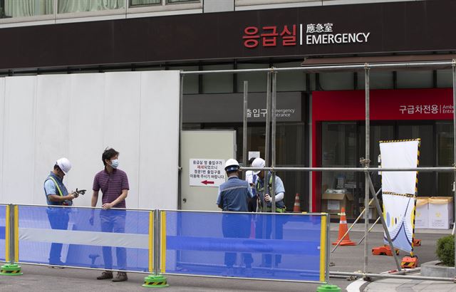 14일 오후 서울 강남구 삼성서울병원 응급실 건물 앞에서 병원 관계자들이 펜스를 설치하고 있다. 이날 삼성서울병원에서 열린 기자회견에서 송재훈 병원장은 "이날부터 신규 외래·입원 환자를 한시적으로 제한하며 응급수술을 제외하고는 수술과 응급진료도 한시 중단한다"고 밝혔다. 연합뉴스