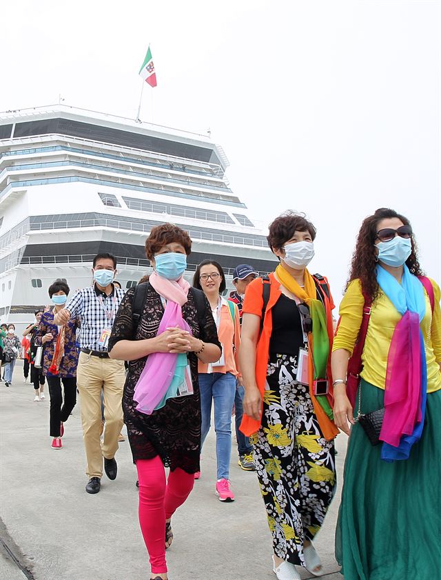 메르스(MERS·중동호흡기증후군) 감염 우려가 날로 확산되는 가운데 11일 오후 제주항에 정박한 11만t급 국제크루즈 코스타 세레나호에서 중국인 관광객들이 마스크를 쓴 채 내리고 있다제주=뉴시스