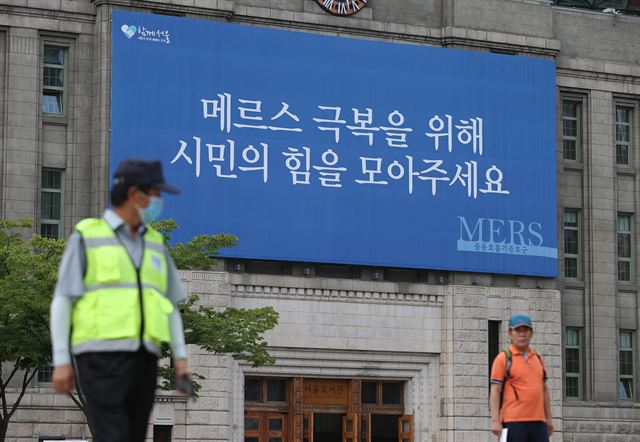 18일 서울 중구 시청 앞 서울도서관 벽에 '메르스 극복을 위해 시민의 힘을 모아주세요'라고 적힌 대형 현수막이 걸려 있다. 연합뉴스