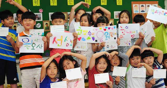 경기 양평군 양서초등학교 학생들이 18일 오전 교실에서 중동호흡기증후군(메르스)과 사투를 벌이고 있는 동탄성심병원 의료진에게 보내는 감사 편지와 그림을 손에 든 채 하트 모양을 만들고 있다. 양평=연합뉴스