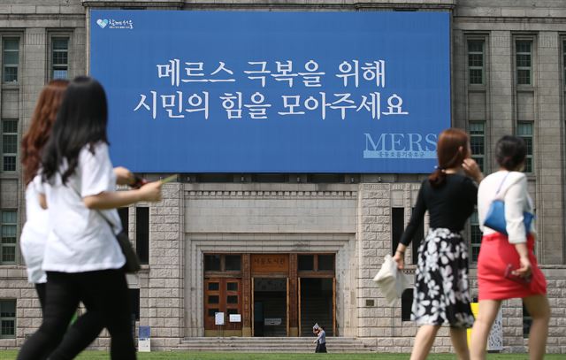 18일 서울 중구 시청 앞 서울도서관 벽에 ‘메르스 극복을 위해 시민의 힘을 모아주세요’라고 적힌 대형 현수막이 걸려 있다. 연합뉴스