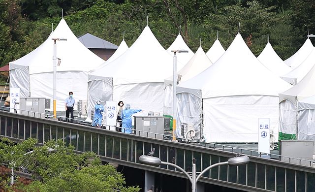 19일 오후 서울 강남구 일원동 삼성서울병원 주차장 옥상에 설치된 중동호흡기증후군(메르스) 선별진료소에서 방호복을 입은 의료진 등이 바쁘게 움직이고 있다. 연합뉴스