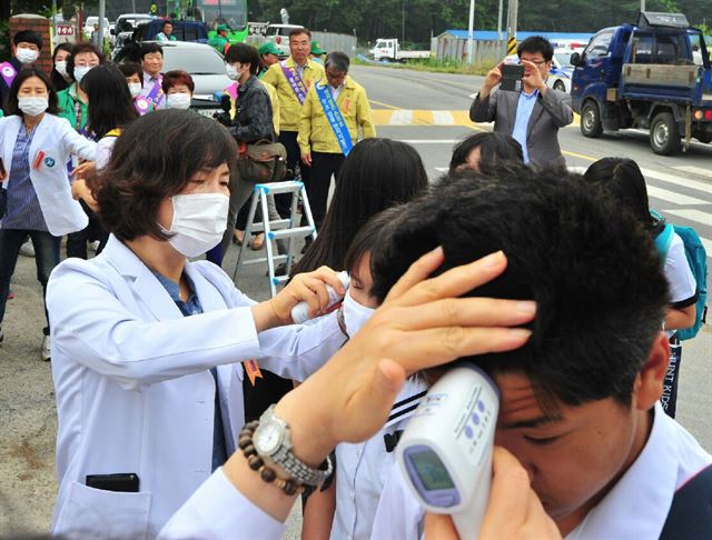 메르스 사태로 지난 15일부터 휴업에 들어갔던 포항 기계 중·고가 22일부터 정상수업에 들어갔다. 만일을 대비해 보건소 직원들이 등교학생들의 체온을 재고 있다. 연합뉴스