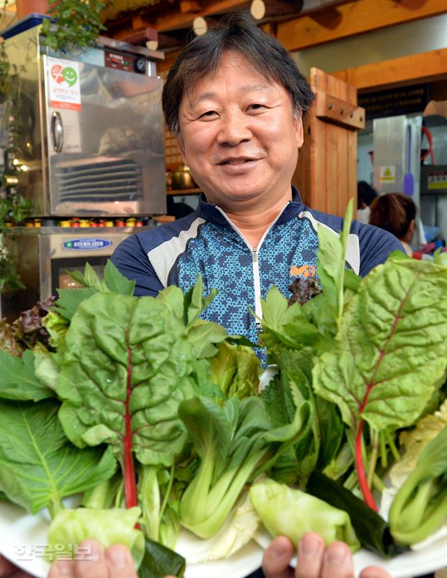 악덕 건물주가 판치는 세상에 "임대료 안 올리겠다. 5년간 나가란 말도 않겠다"고 말하는 '착한 건물주' 김성구씨가 지난 16일 자신이 세입자로 영업 중인 식당에서 재료를 들고 환하게 웃고 있다. 서재훈기자 spring@hankookilbo.com