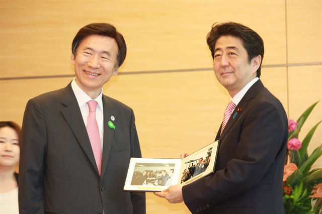 윤병세 외교부 장관이 22일 도쿄 총리관저를 예방차 방문, 아베 신조(安倍晋三) 총리와 면담했다. 윤 장관이 아베 총리의 선친인 아베 신타로(安倍晋太郞) 전 외무상의 사진을 선물하자 아베 총리가 취재진에 사진을 보여주고 있다. 연합뉴스