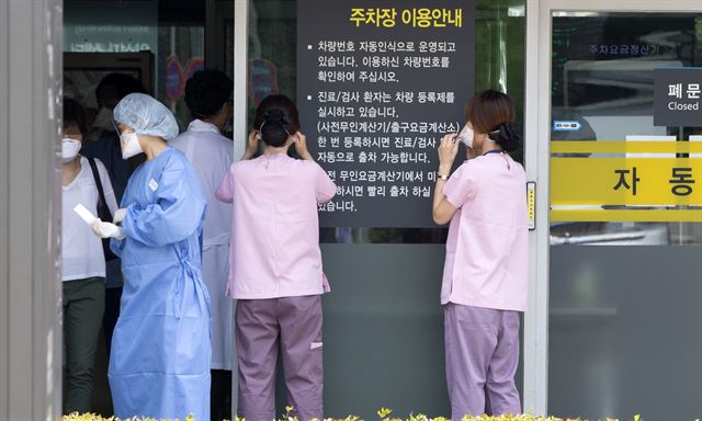 중동호흡기증후군(메르스) 사태가 장기화 국면에 접어든 가운데 22일 오후 강남구 삼성서울병원 의료진이 주차장에 설치된 메르스 대응 시설물에 들어서기 위해 마스크를 착용하고 있다. 연합뉴스