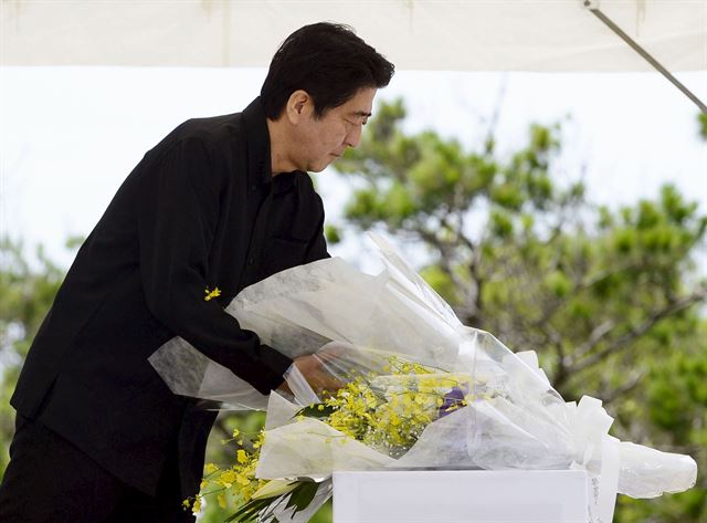 아베 신조 일본 총리가 23일 오키나와 이토만의 평화기념공원에서 열린 태평양전쟁 오키나와 전투 전몰자 추도식에 참석해 헌화하고 있다. 오키나와=로이터ㆍ연합뉴스