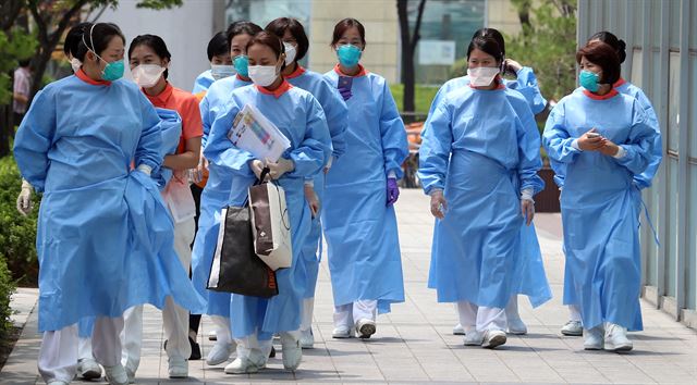 보건당국이 중동호흡기증후군(메르스) 확산을 막기 위해 서울 광진구 건국대병원에 병원 부분폐쇄 조치를 내린 24일 병원관계자들이 마스크를 착용한 채 병원 로비로 가고 있다. 연합뉴스