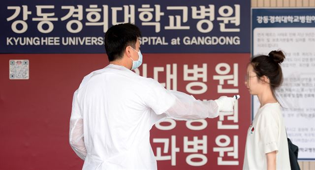 메르스(MERS, 중동호흡기증후군)로 인해 전면적 진료폐쇄 상태로 운영중인 28일 오후 서울 강동구 강동경희대학교병원에서 의료진이 내원객들의 온도를 체크하고 있다. 보건복지부 중앙메르스관리대책본부는 강동경희대병원 간호사 1명이 메르스(MERS, 중동호흡기증후군)확진 판정을 받았다고 했지만 발열 등 증상이 없는 무증상 확진자로 확인됐다 밝혔다. 뉴시스