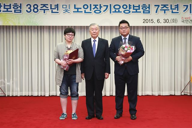 ‘노인장기요양보험 체험수기 및 사진’ 공모전에서 최우수상을 수상한 김시은(왼쪽) 김오근(오른쪽)씨가 30일 수상 직후 성상철 건강보험공단 이사장과 함께 기념사진을 찍고 있다. 국민건강보험공단 제공