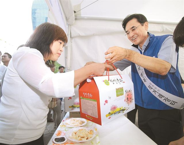 2일 삼성이 내수를 살리기 위해 이달 중순 '농산물 직거래 장터'를 연다. 지난해 추석 때 서울 서초동 삼성전자 사옥 앞에서 같은 방식으로 열린 장터에서 삼성 임원이 유과를 팔고 있다. 삼성 제공