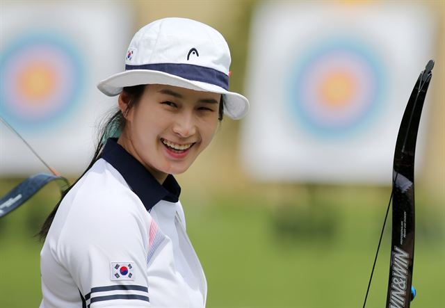 한국여자 양궁 대표팀 기보배가 4일 오전 광주 서구 광주국제양궁장에서 열린 2015 광주하계유니버시아드 양궁 리커브 랭킹라운드에서 코치진과 대화를 나누던 중 미소를 보이고 있다. 기보배는 세계신기록을 세우며 1위를 차지했다. 연합뉴스