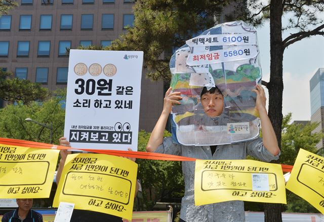 최저임금연대 회원들이 6일 오후 서울 종로구 보신각 앞에서 열린 최저임금 1만원을 촉구하는 문화제에서 최저임금에 대한 불만을 담은 피켓을 들고 있다. 뉴시스